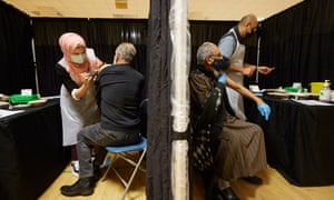 Members of the local community receive their vaccinations at the East London Mosque