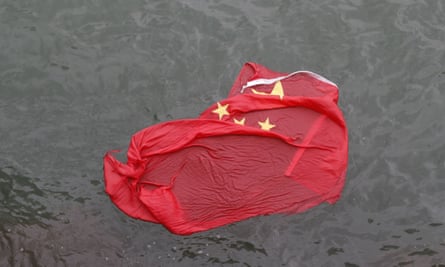 A Chinese flag floats on the surface after it was thrown in the water by protesters
