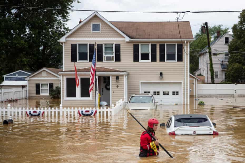 A rescue crew member wades through high waters following a flash flood, as Tropical Storm Henri makes landfall, in Helmetta, New Jersey, on Sunday.