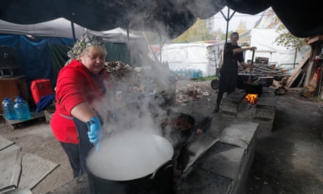 Ukrainian volunteers cooking and distributing hot meals in Kyiv.
