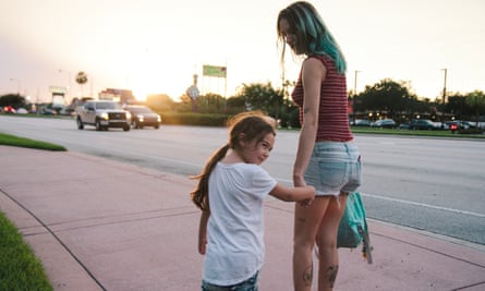 Brooklynn Prince and Bria Vinaite walking along a street holding hands.