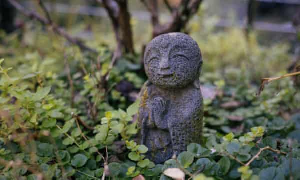 A garden Buddha stands in Tara Brach’s garden.