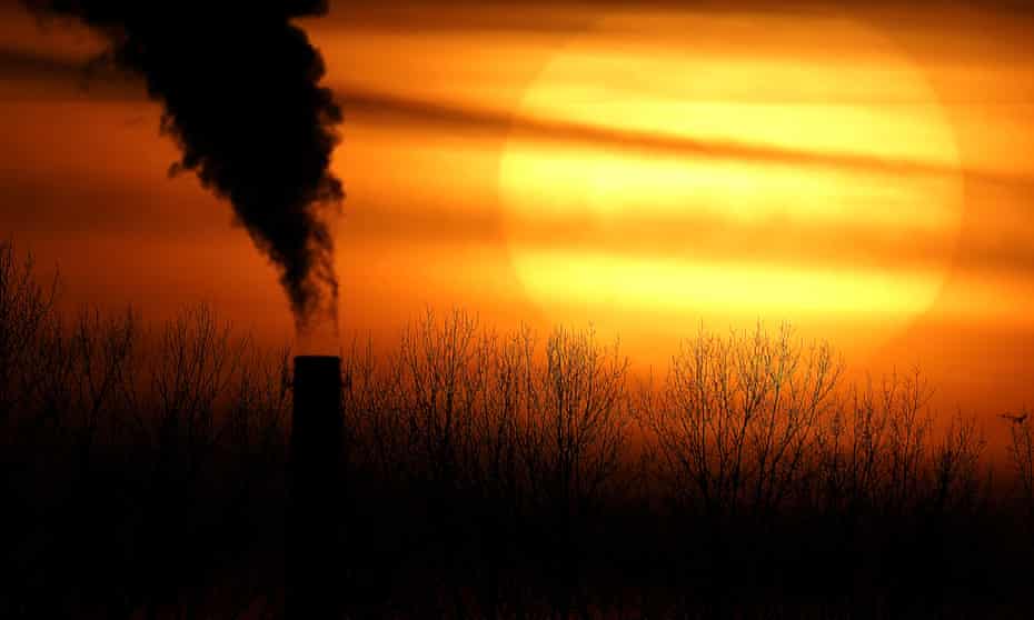 A smokestack from a Evergy’s Hawthorn coal-fired power plant is silhouetted against the setting sun in Kansas City, USA