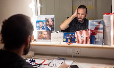 Behind the scenes with Joseph Fiennes reflected in a mirror. There are photographs of Gareth Southgate stuck to the mirror