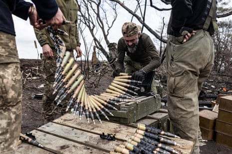 Ukrainian soldiers prepare shells for a BMP during training.