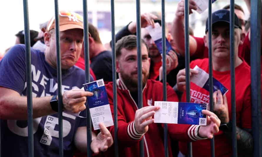 Liverpool fans stuck outside the ground show their match tickets.