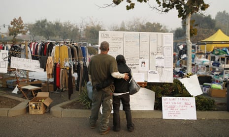 A couple displaced by the Camp fire in 2018 look at an information board. 