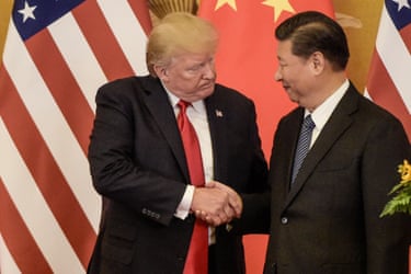 President Donald Trump shakes hand with President Xi Jinping with Chinese and US flags behind them