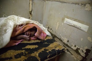 A newborn baby on a patient trolley at Lira hospital, Uganda.