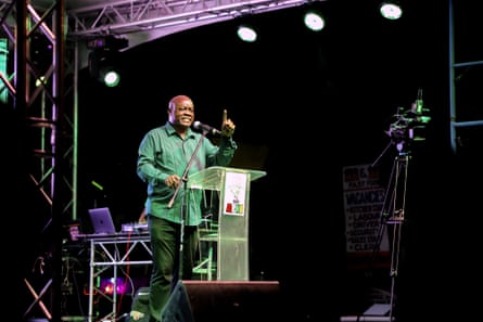 A man speaks into a microphone on stage.