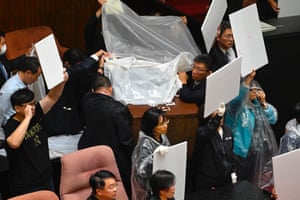The DPP sides uses boards and sheets to block KMT water balloons