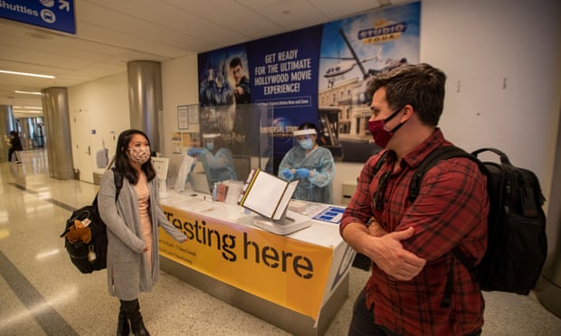 Travelers Angela Buckley and Wade Hopkins talk after taking a Covid-19 test at a testing station at LAX airport in Los Angeles.