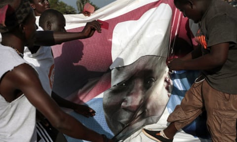 Gambians celebrate the victory of opposition coalition candidate Adama Barrow by tearing down a poster of longtime President Yahya Jammeh in Serrekunda, Gambia, 2 December 2016. 