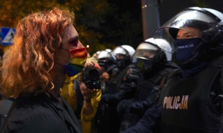 A protester confronts police in Warsaw