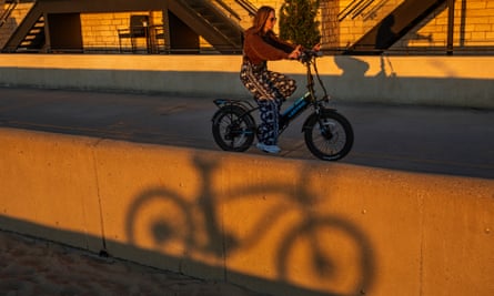 A woman rides an e-bike on the beach in Hermosa Beach, California.