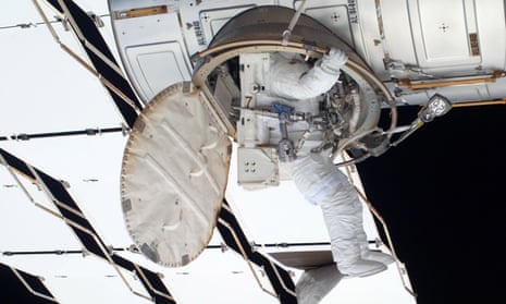 An astronaut climbs into the International Space Station