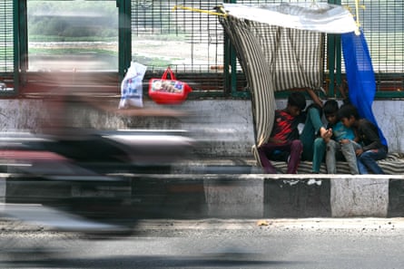 Boys sit beneath a makeshift canopy in Delhi. Boys sit beneath a makeshift canopy in Delhi.