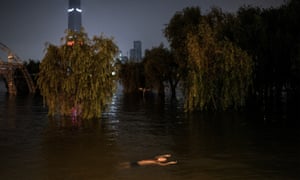 A resident swims in flood waters at Jiangtan Park in Wuhan