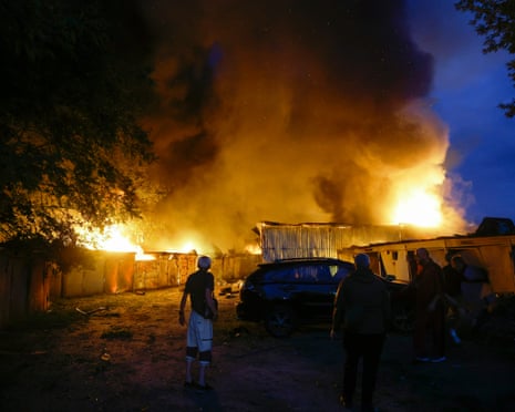 Local residents battle a fire during a large-scale combined Russian attack on a residential area in Kyiv.