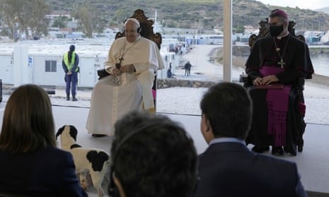 Pope Francis and a dog have a moment during a ceremony at a refugee camp on Lesbos, Greece