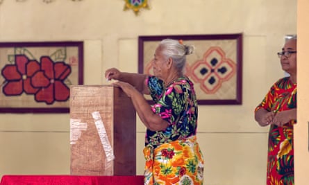A woman places her vote into a ballot box on election day in Funafuti, the capital of the south Pacific nation of Tuvalu