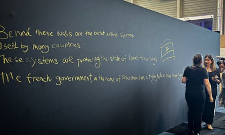 Graffiti reads "Behind these walls are the best defense systems used by many countries. These systems are protecting the state of Israel these days. The French government, in the name of discrimination is trying to hide them from you"