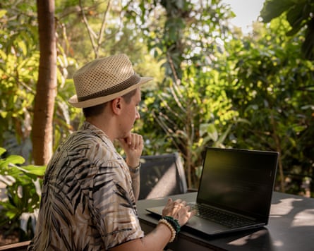 Tagliabue works on his laptop in a cafe in Thailand.