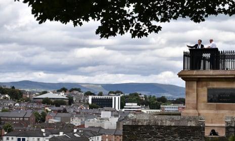 Julian Smith (L) looks out from Derry’s walls over the Bogside alongside William Moore (R), chairman of the Siege Museum on his first official engagement in Northern Ireland.