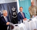 Denmark's defence minister and intelligence chief stand at tables during a press conference, as a general stands nearby.