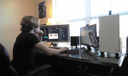 young man looking at computer screens with data on them