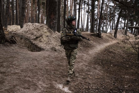 Artem Volynko, 25, carries a weapon as soldiers on the frontline.