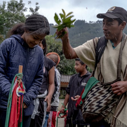 Nasa shaman sprinkles Angie Barrera with herbal tincture