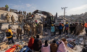 Rescue workers and local volunteers search for survivors in the debris of buildings in Hatay, Turkey.