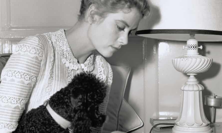 Grace Kelly, primly dressed and reading a script with her black French poodle tucked under her arm