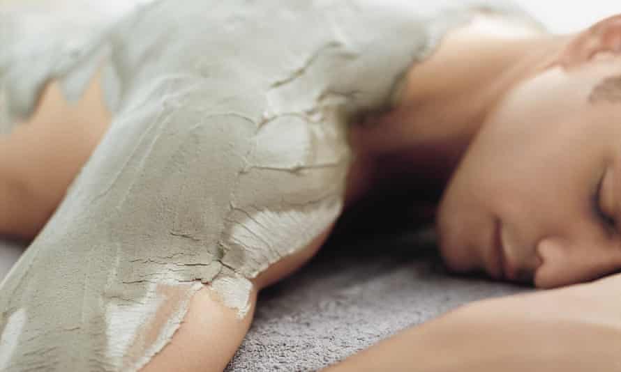 A sleeping woman caked in a mud-like substance.