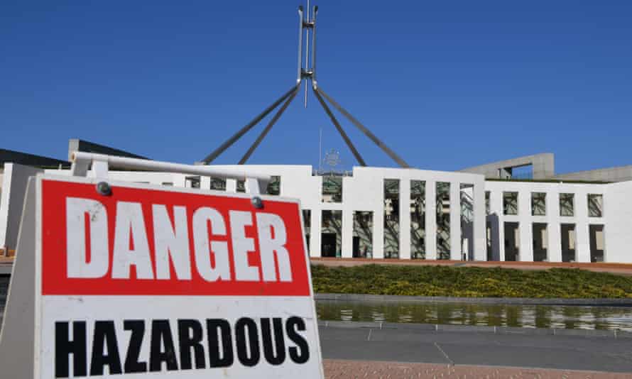 parliament house in canberra with a 'danger hazardous' sign out of the front