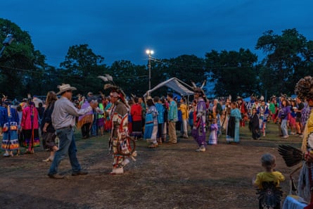 A group of people dancing, some in indigenous clothing