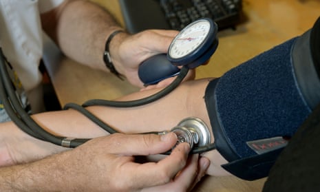 A doctor takes a patient's blood pressure.
