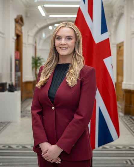 Kate Dearden in a civic building with a union flag behind her.