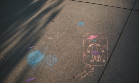 Evening sunlight shines on a child’s pavement chalk drawing.