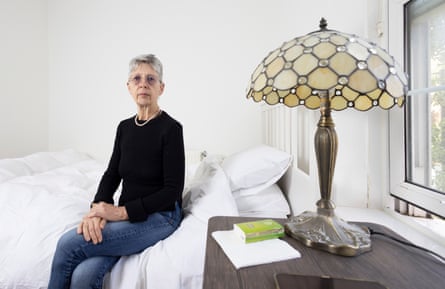 Deborah Herring sitting on a bed in her shared accommodation