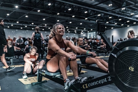 A woman pulls on a rowing machine cable