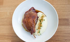Duck and mashed potato on a round white plate