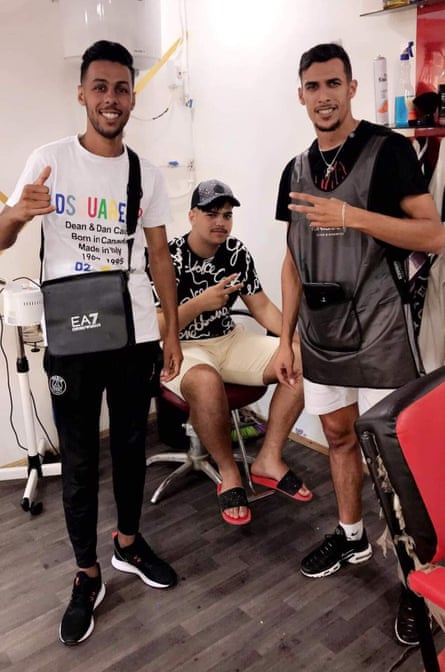 Oussama Tayeb (right) wearing chain with tiny set of scissors and comb