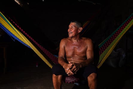 Un hombre se sienta en una hamaca en la oscuridad.