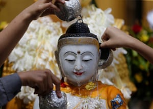 Yangon, Myanmar: devotees pour water on to a Buddha figurine