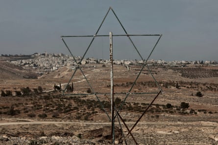 A large metal star of David in a landscape