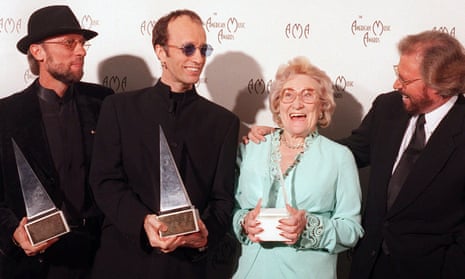 The Bee Gees after winning the 1997 International Award at the American Music Awards, posing with their mom, Barbara Gibb.
