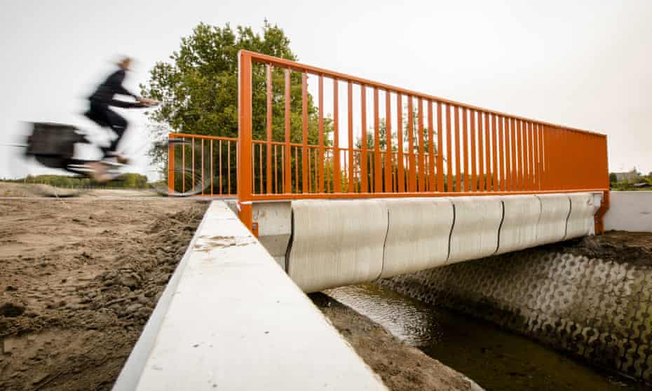 A cyclist crosses the 3D-printed concrete bike bridge in Gemert.