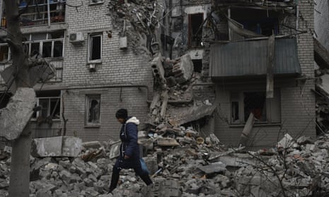 A woman walks past debris of a destroyed house after a recent Russian air strike in Chasiv Yar, Ukraine.